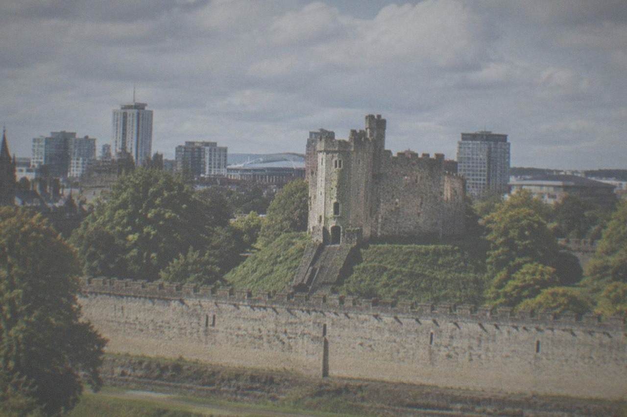 Cardiff Castle keep with the city skyline behind it on a bright morning
