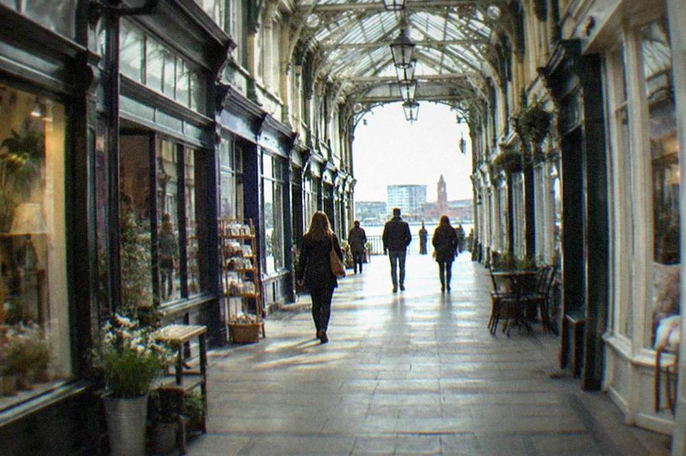 A covered Victorian arcade in Cardiff with small independent shopfronts along both sides