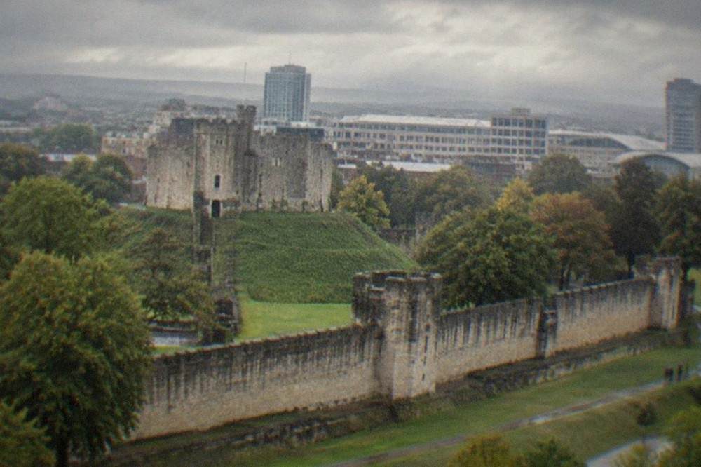 Cardiff Castle keep with the city skyline behind it on a bright afternoon