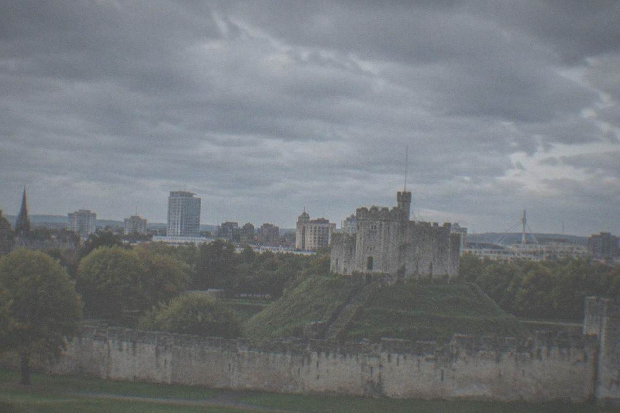 Cardiff Castle keep with the city skyline behind it on a bright afternoon