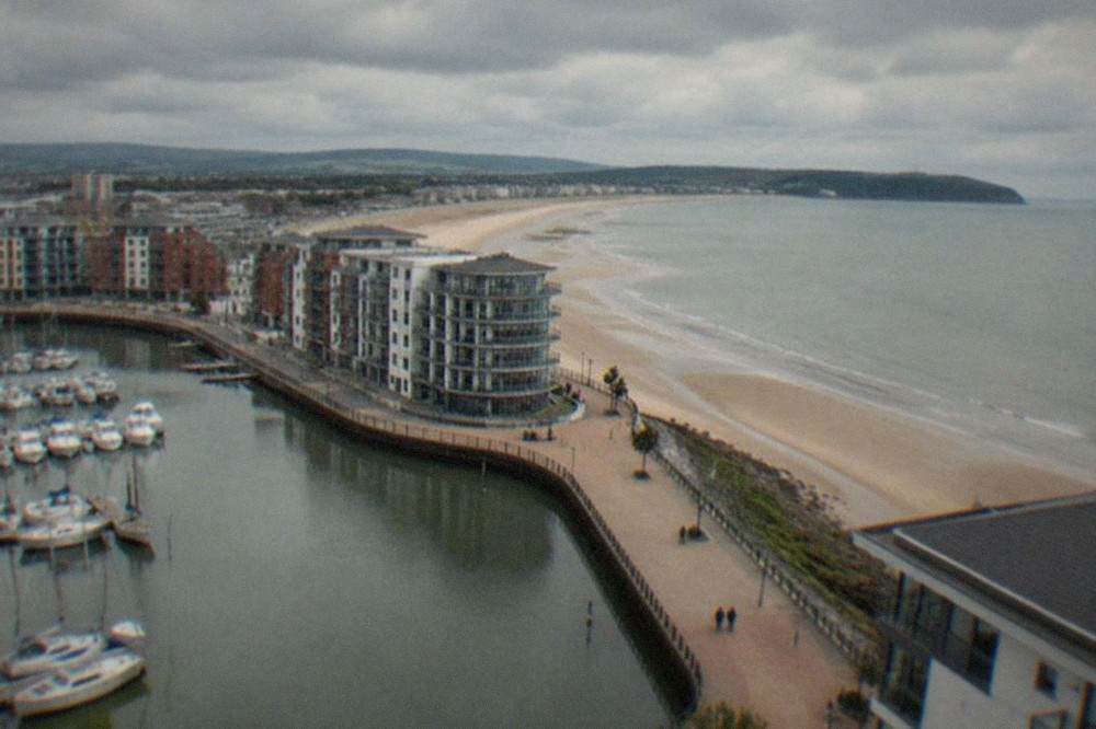 Swansea seafront promenade with a wide sandy bay curving into the distance