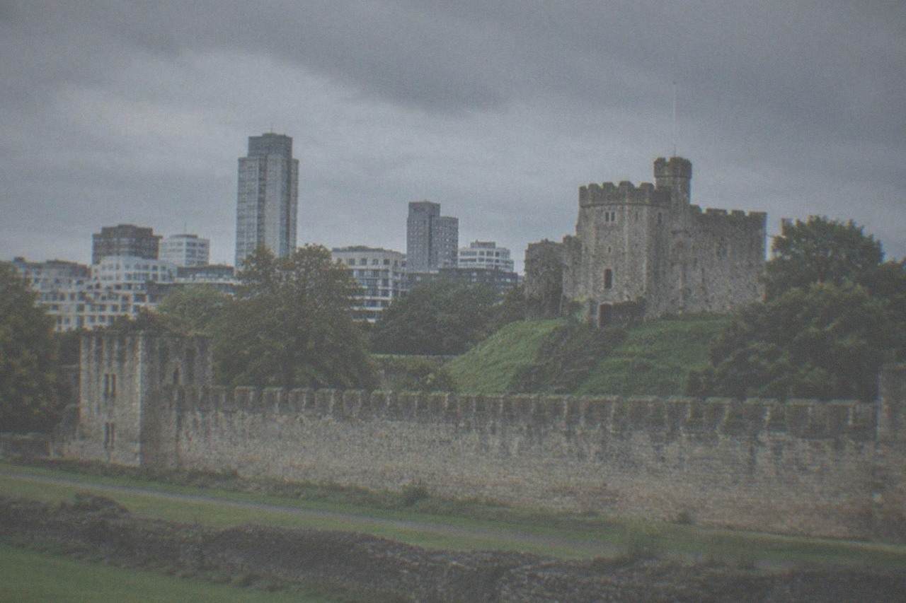 Cardiff Castle keep rising above the city skyline with modern buildings behind it