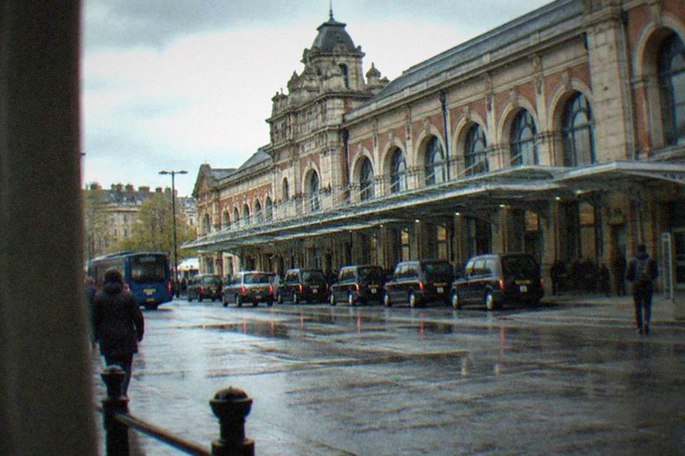 A wide city street with Victorian arcades and shoppers under a glass roof
