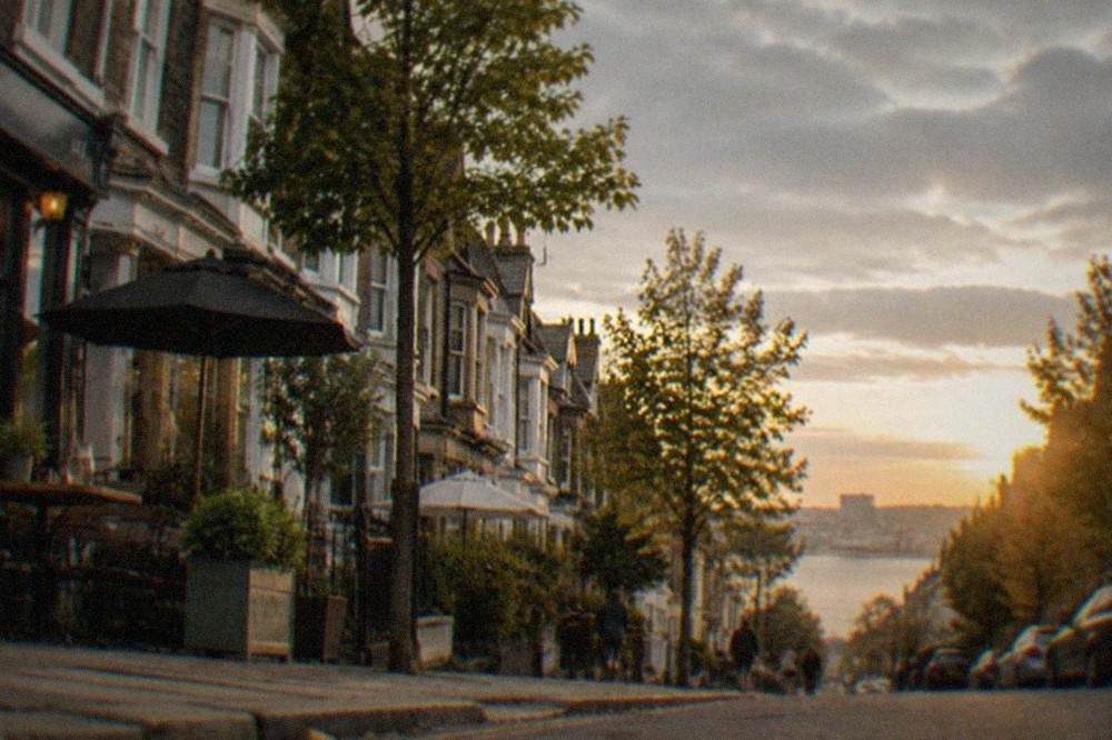 Tree-lined Victorian terrace street with cafés and independent shopfronts in a quiet Cardiff neighbourhood