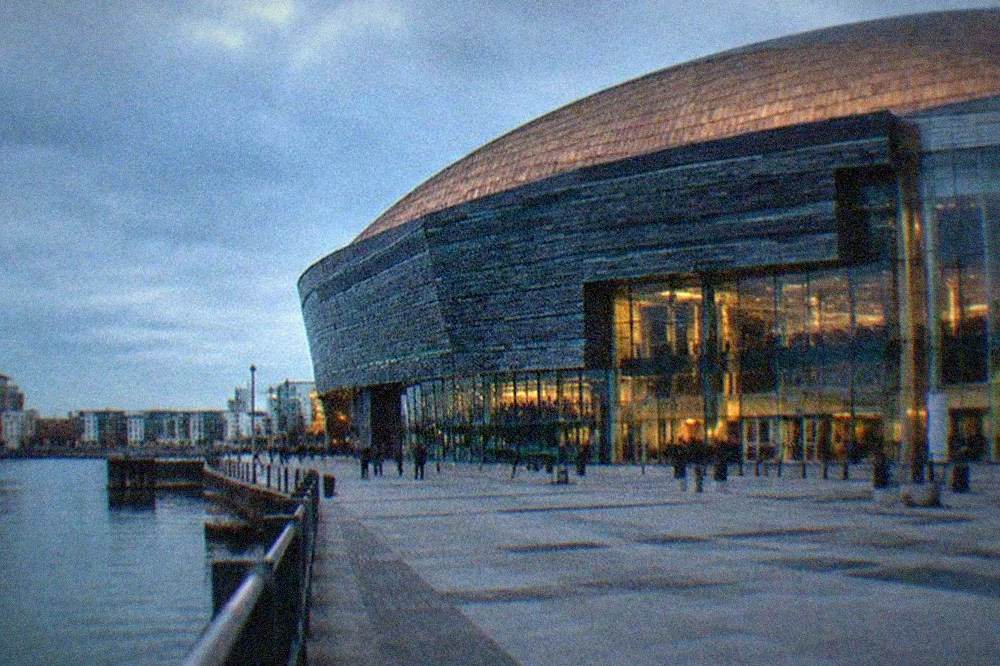 The Wales Millennium Centre facade beside the calm water of Cardiff Bay