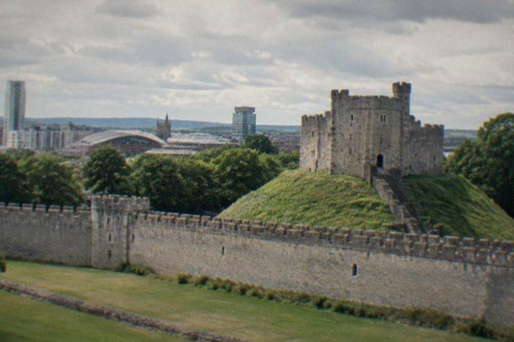 Cardiff Castle keep with the city skyline behind it on a bright day