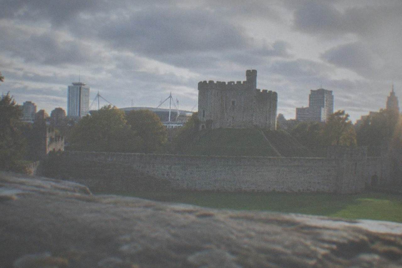 Cardiff Castle keep with the city skyline behind it on a bright day
