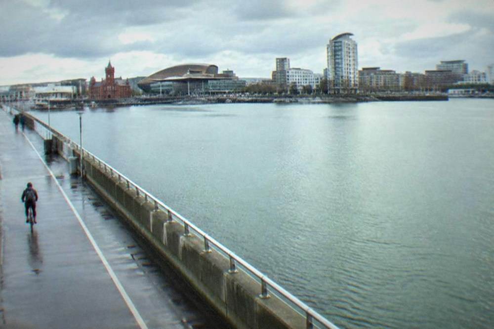 Cardiff Bay Barrage path alongside the harbour water with the city skyline behind