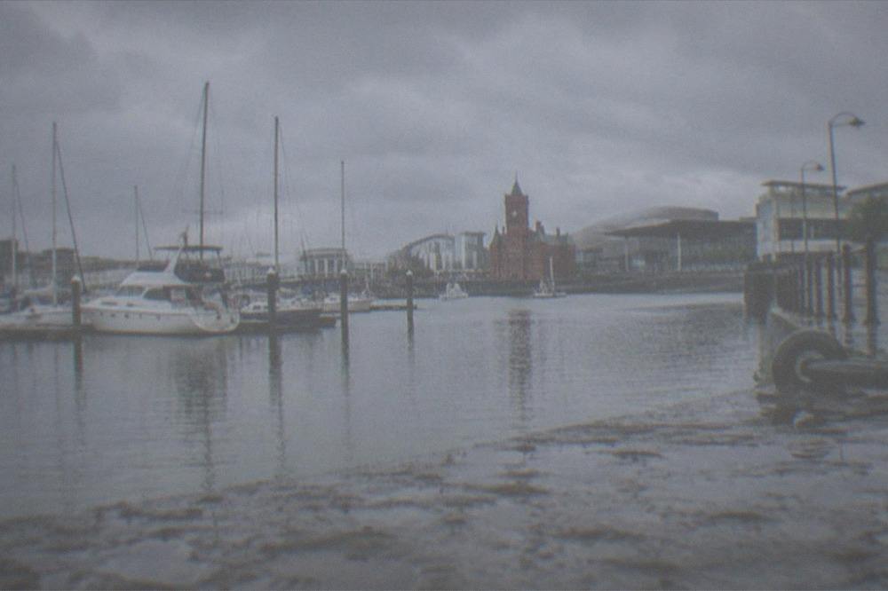 Late summer afternoon on Cardiff Bay with calm water, moored boats and the waterfront promenade