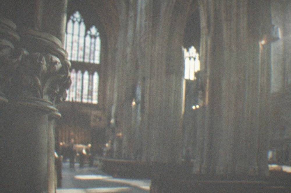 A cathedral interior with tall stone columns and light falling on a wide nave