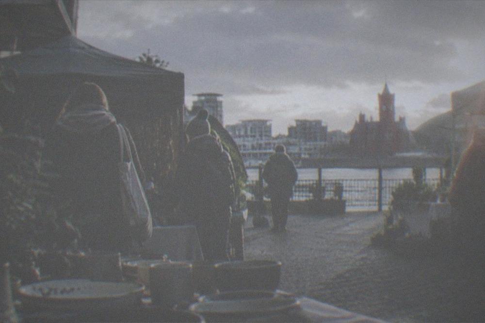 People browsing market stalls set out in a small urban yard