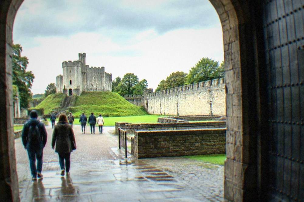 Visitors walking through the stone archway entrance of Cardiff Castle