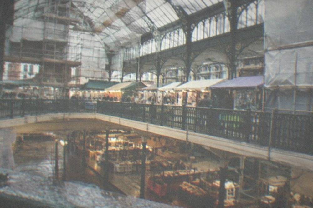 Scaffolding and protective sheeting inside a market hall under restoration