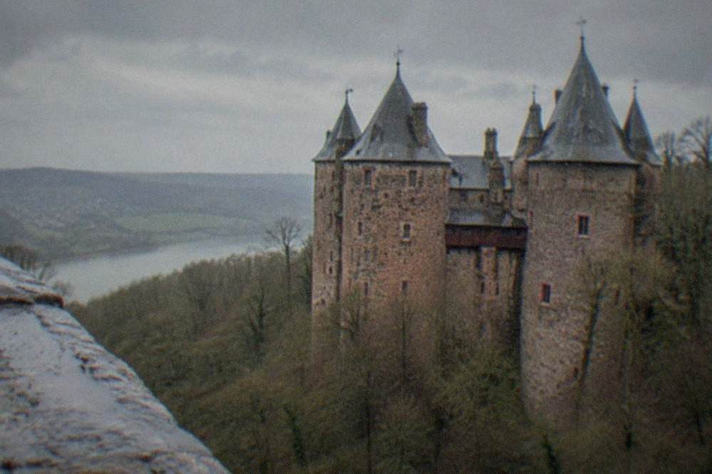A turreted Gothic revival castle on a wooded hillside above the Taff Valley