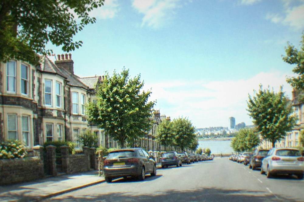 Tree-lined residential street with terraced houses in a Cardiff district
