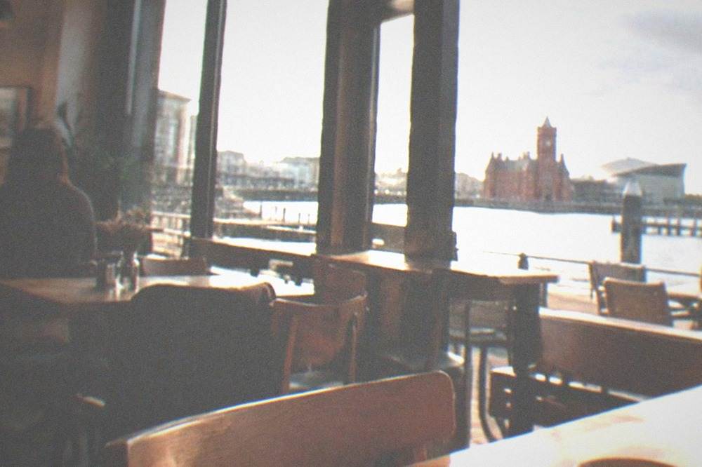 Cafe interior with wooden tables and chairs in soft daylight