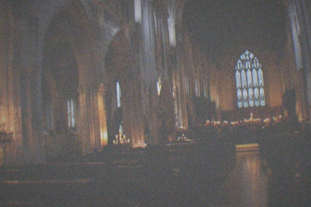 A cathedral nave lit by candles before an evening concert