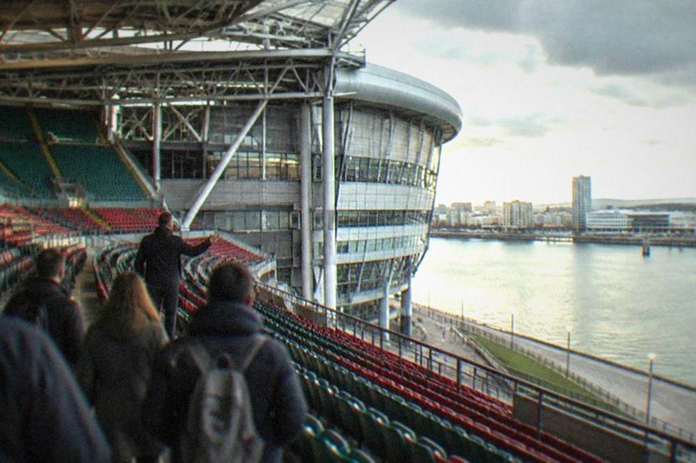 A stadium tour guide leading a small group along an empty seating tier