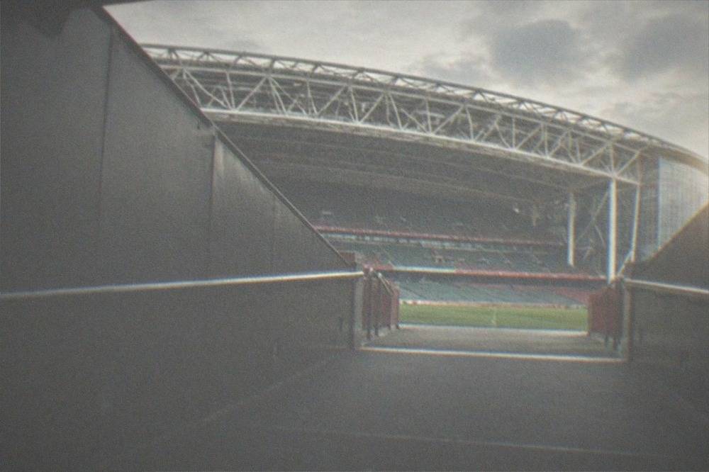 An empty players' tunnel leading toward a bright pitch entrance
