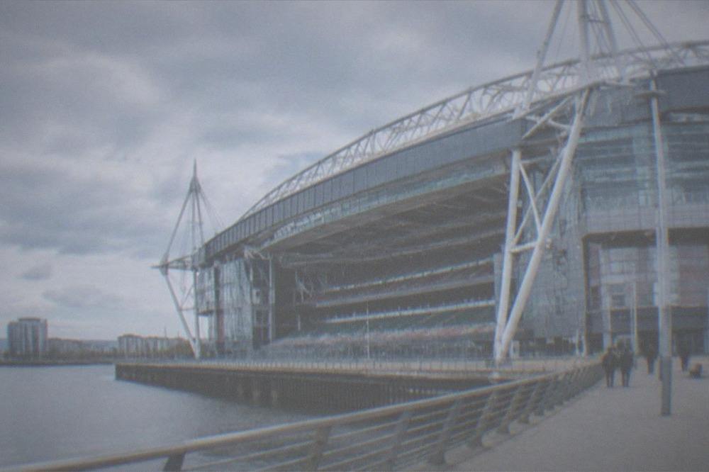 A stadium pitch prepared for an event with seating tiers rising around it