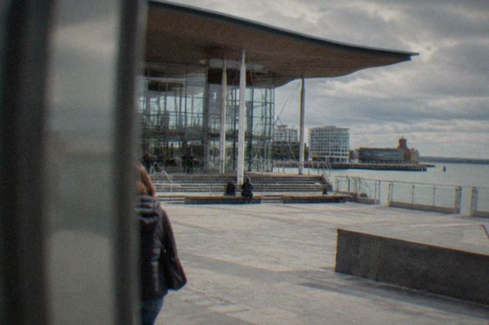 The glass and steel frontage of the Senedd building on a bright day