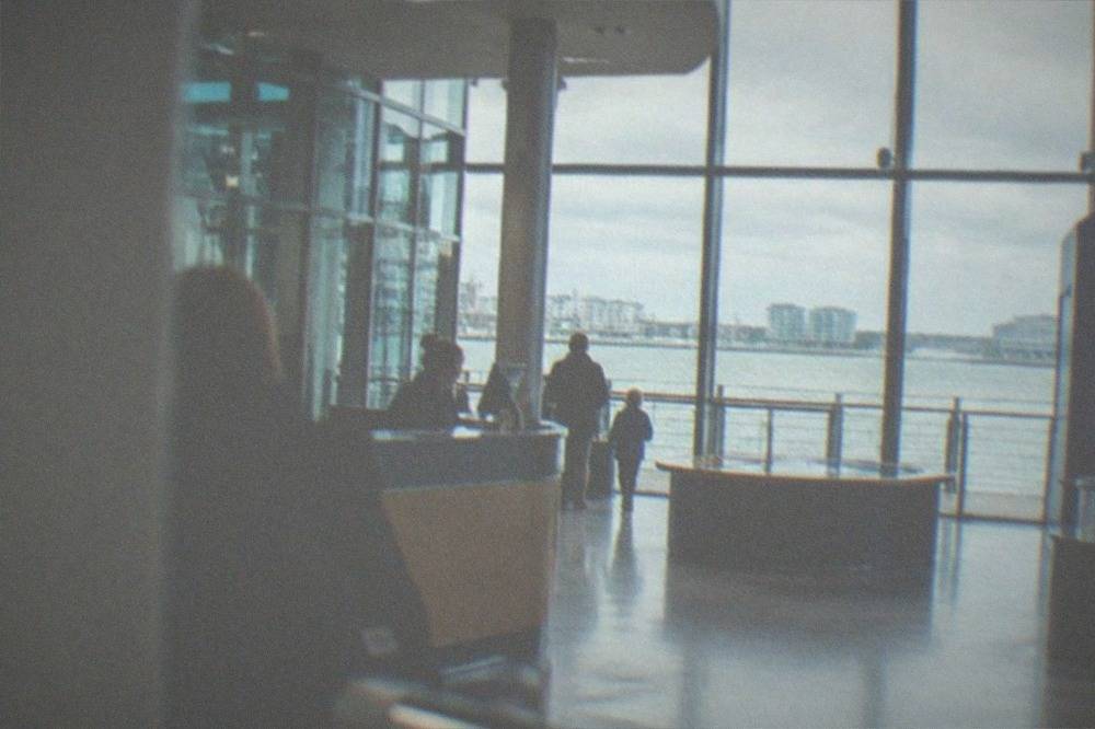 Entrance foyer of a science centre with ticket desk and daylight through glass walls