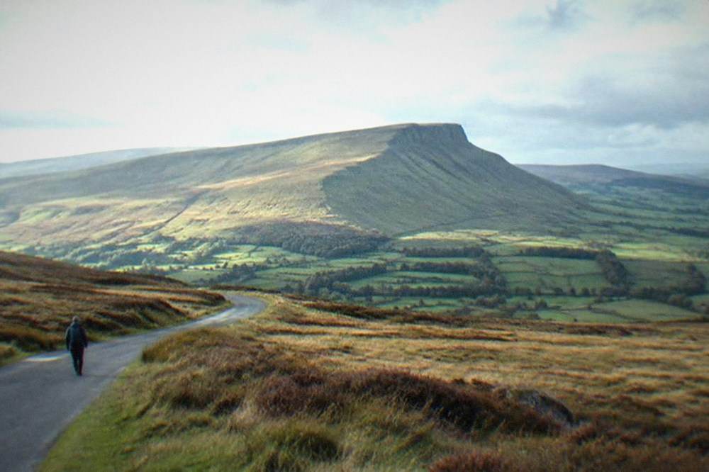 A winding road crossing open moorland toward distant peaks