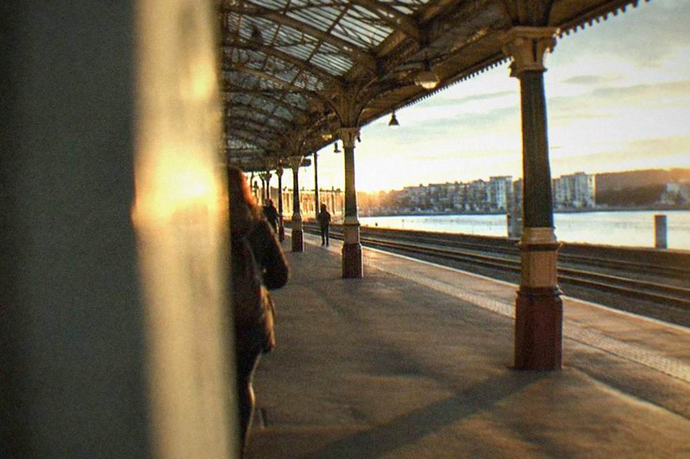 A railway platform with a long Victorian train shed roof