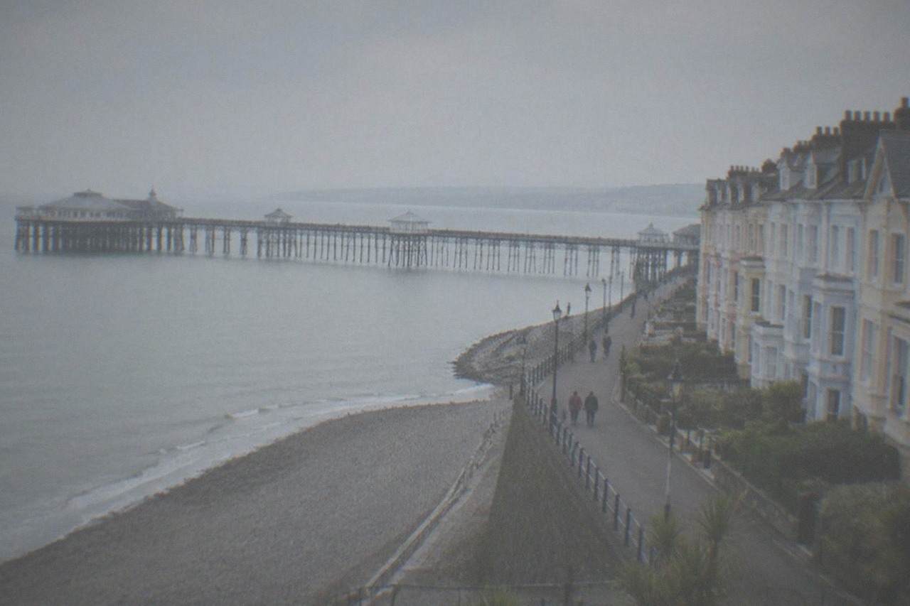 A Victorian pier stretching into the sea from a small Welsh seaside town