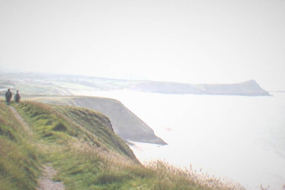 Coastal footpath along a grassy clifftop above the sea