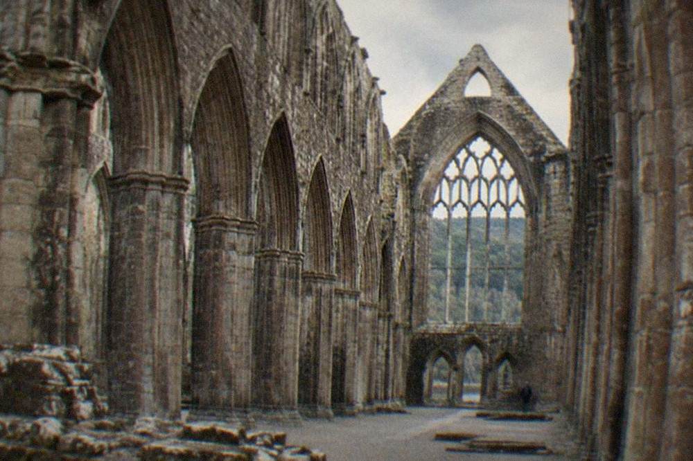 Stone arches of an abbey ruin seen from inside the nave