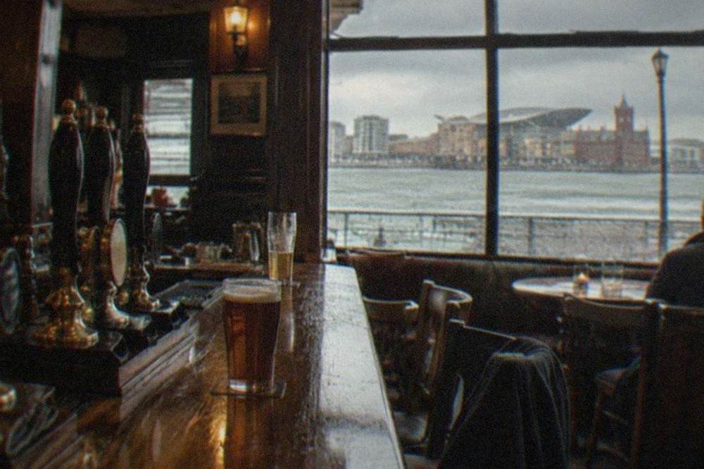 A dimly lit traditional pub bar with hand pulls and wooden panelling