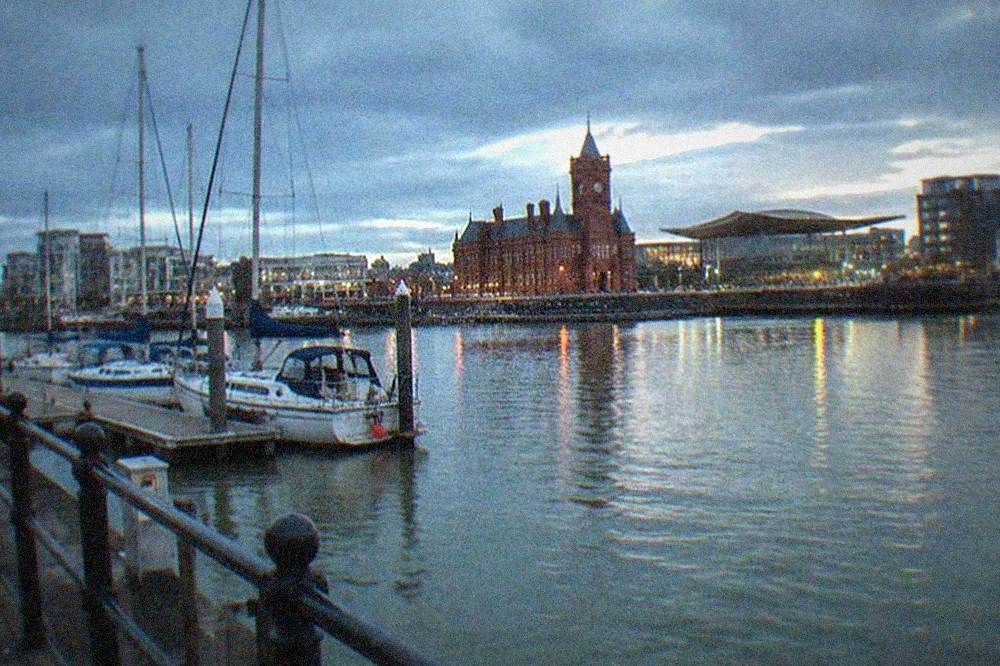Sunny waterfront at Cardiff Bay with boats moored along the quay