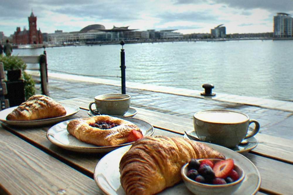 A row of brunch plates with fresh pastries and coffee