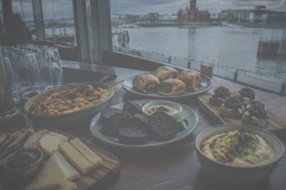 A spread of Welsh food samples on a bar counter
