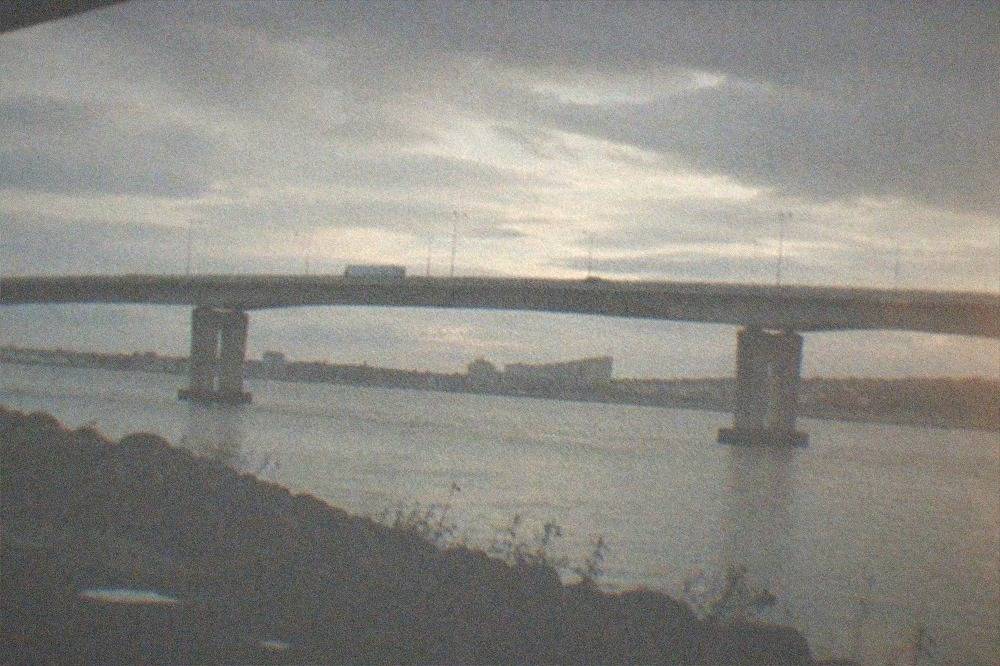 A motorway bridge crossing a wide river estuary at dusk