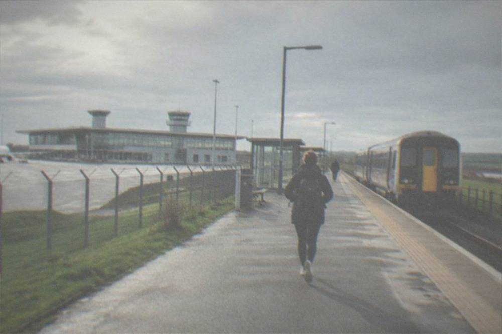 A two-car regional train waiting at a small country railway station platform