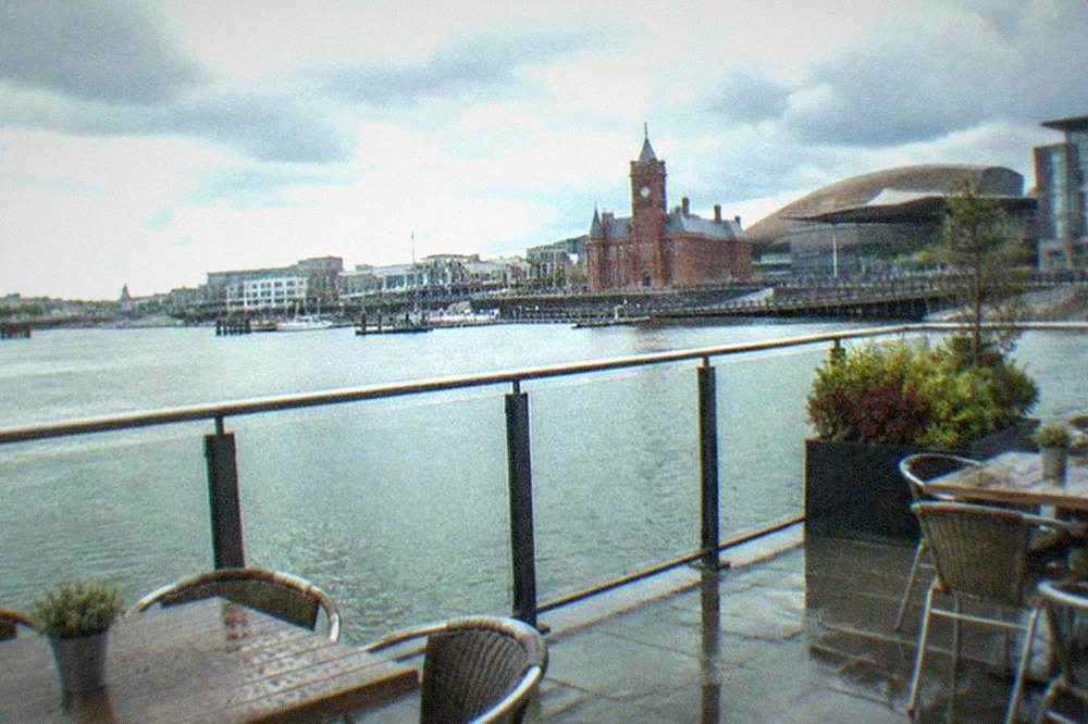 Outdoor terrace with tables overlooking Cardiff Bay