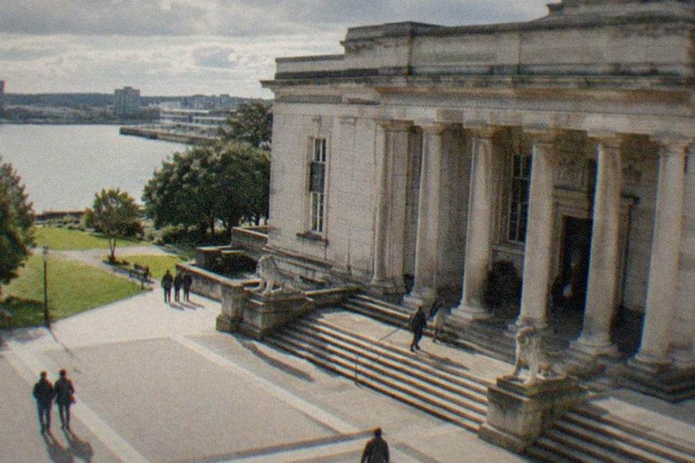 A grand stone museum building with a columned entrance under a bright sky
