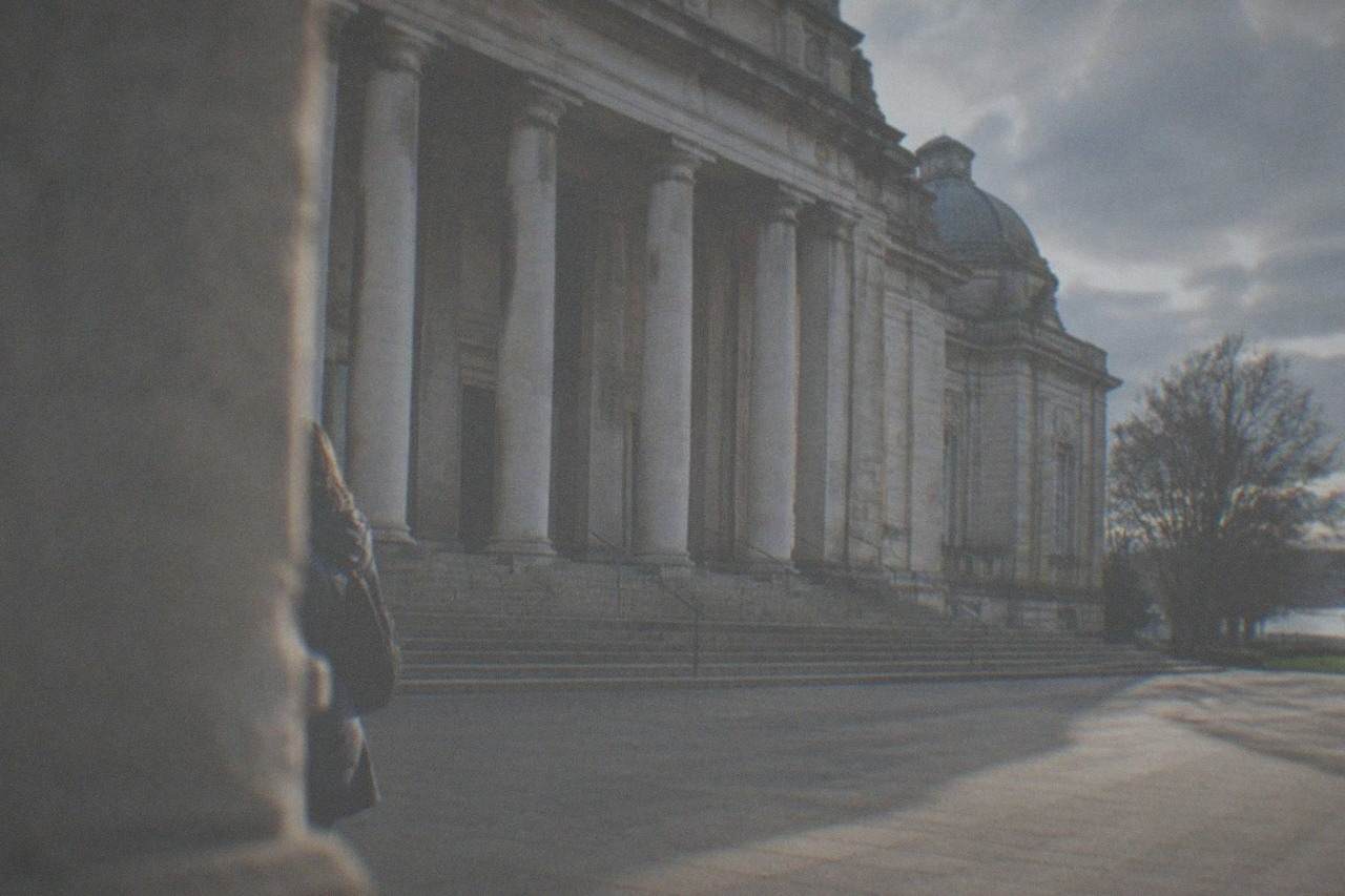 A grand stone museum building with a columned entrance under a bright sky
