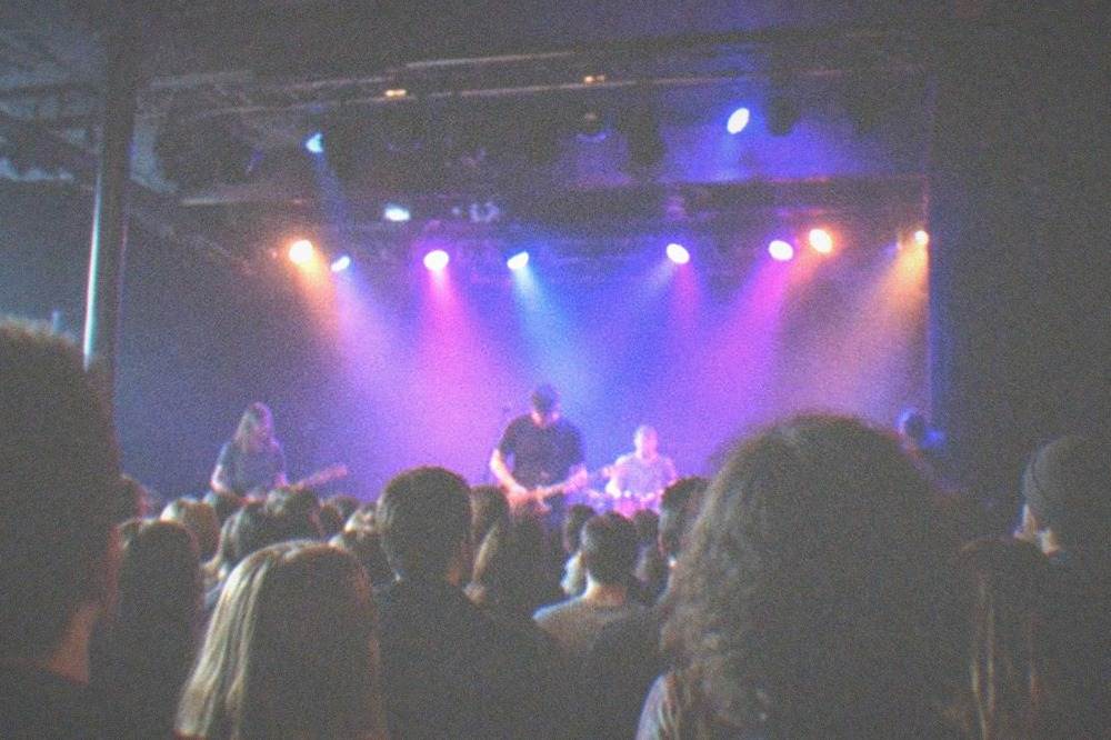 Small music venue interior with stage lighting and a crowded floor