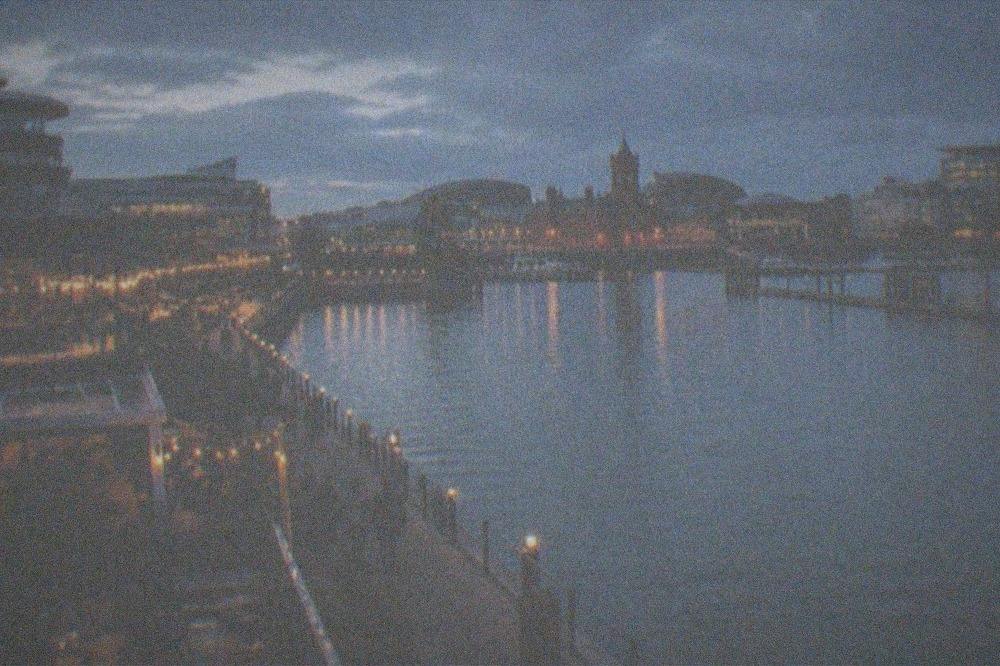 Waterfront restaurants and bars lit up along Cardiff Bay in the evening