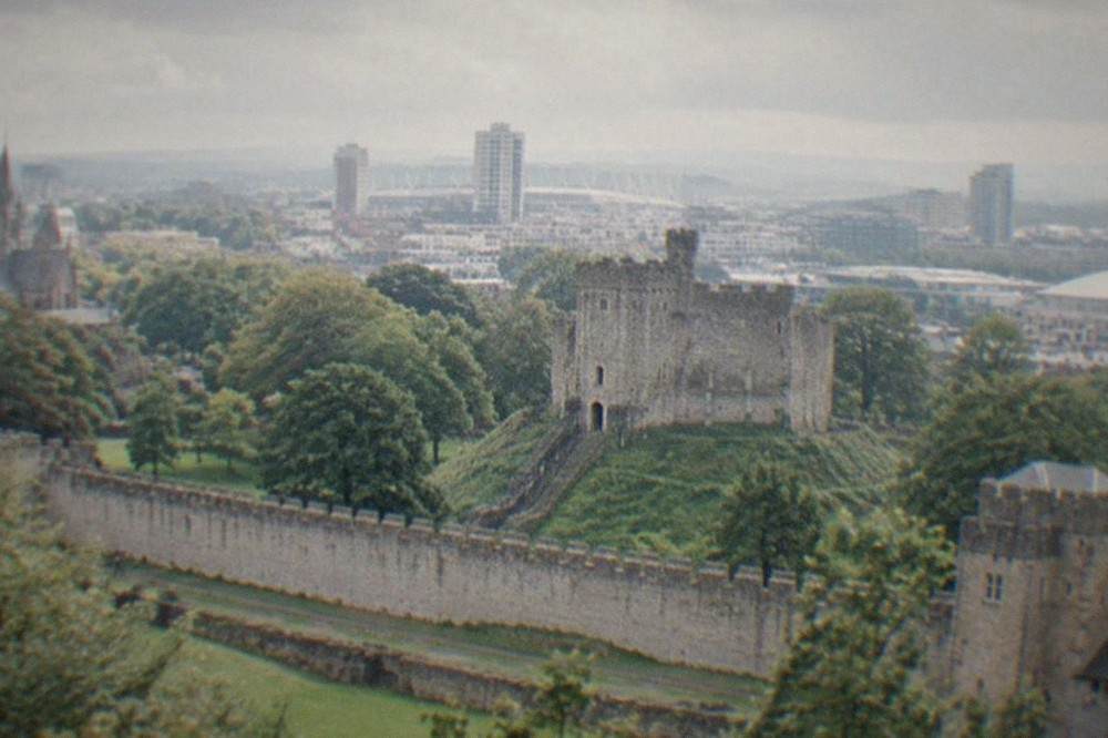 Cardiff Castle keep with the city skyline behind it on a bright day