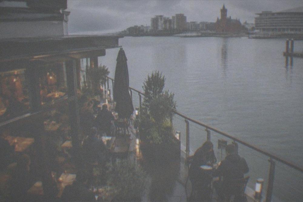 Diners at small tables in a warmly lit independent restaurant