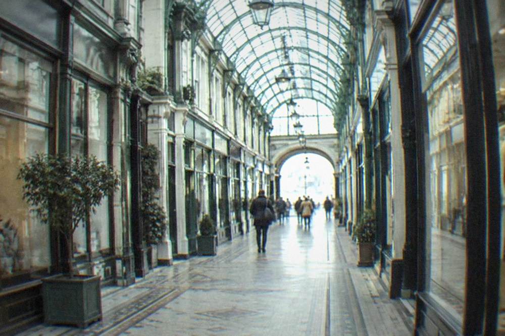Victorian arcades interior with shopfronts under a glass roof