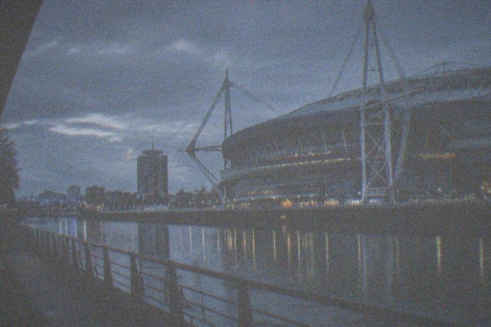 Principality Stadium beside the River Taff at dusk with city lights