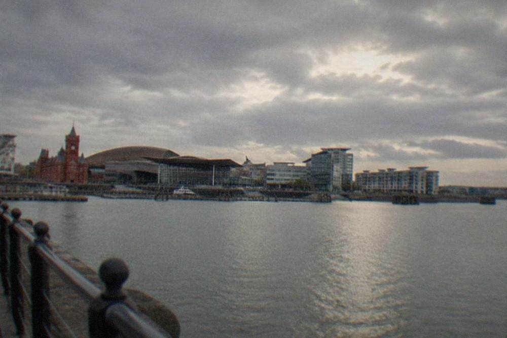 Grey clouds and sunlight over Cardiff Bay waterfront buildings
