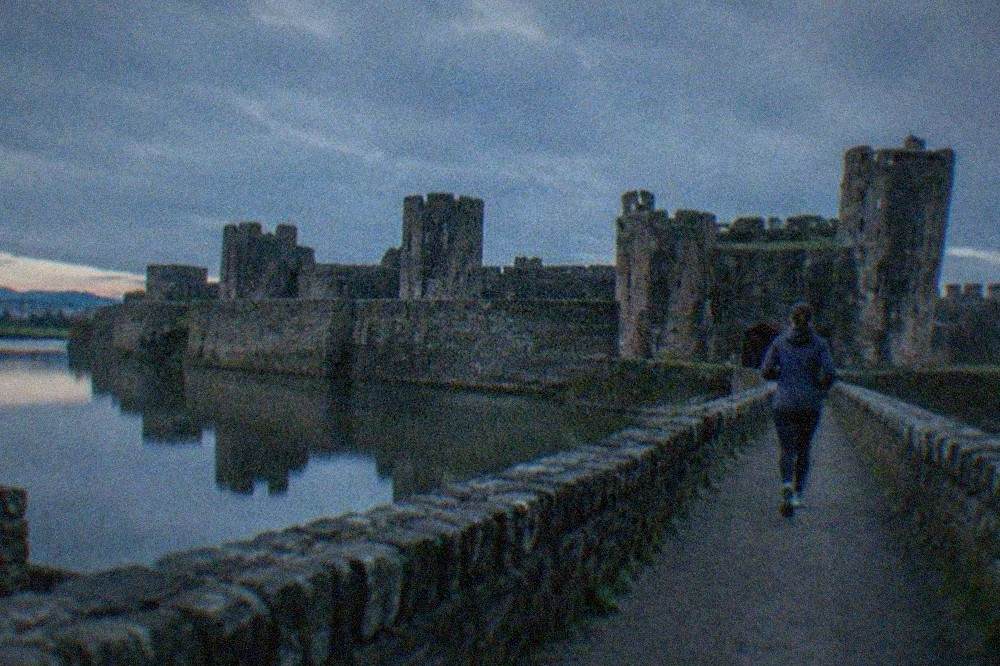Caerphilly Castle towers reflected in surrounding water