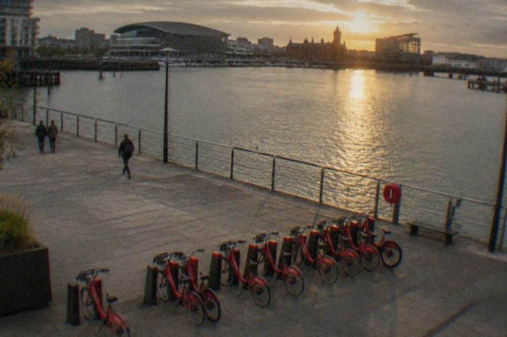 Row of red city bikes parked beside a wide pedestrian square