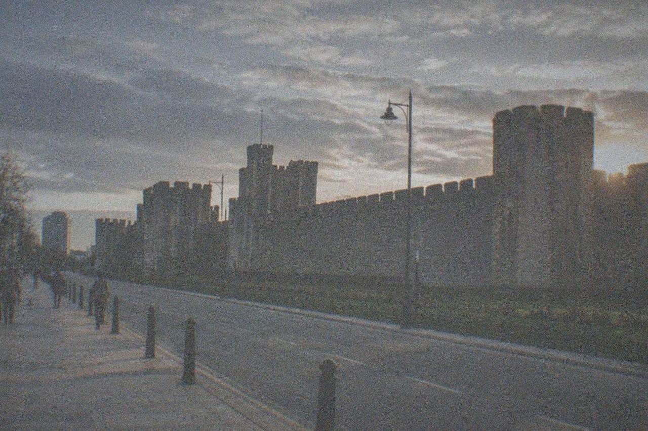 Cardiff city centre street with castle walls in the evening light